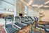 Modern fitness center with state-of-the-art treadmills in a bright and inviting location featuring floor-to-ceiling windows and spiral staircase.