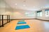 Modern dance studio with mirrored wall, ballet barre, and bright natural light.