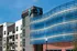 Modern apartment building with contemporary architecture, featuring stylish blue design elements and large windows under a clear blue sky.