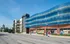 Chic urban apartment building with modern architecture, featuring sleek glass facade and vibrant street views.