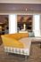 Elegant living space featuring a modern sectional sofa with vibrant yellow accents and stylish cushions, set in a luxurious, well-lit room.