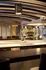 Elegant apartment interior featuring a modern kitchen with sleek countertops, artistic pendant lighting, and a cozy lounge area with a fireplace.