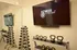 Modern fitness room featuring a sleek TV with 'Fitness on Demand,' a mirrored wall, and neatly organized weights and kettlebells.