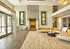 Luxurious apartment lobby featuring contemporary d&eacute;cor with vibrant green accents, a stylish yellow sectional sofa, and elegant wooden flooring.