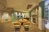 Elegant apartment lounge with modern fireplace, cozy yellow armchairs, and stylish wood flooring, offering a sophisticated and inviting atmosphere.