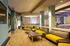 Modern lounge area with stylish yellow seating, sleek tables, and subtle lighting, perfect for relaxation and socializing.