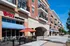 Charming brick apartment complex with inviting outdoor dining and convenient parking access.
