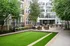 Charming apartment courtyard with lush greenery, stylish seating area, and modern outdoor kitchen in a serene setting.