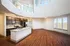 Elegant open-concept living space with a stylish kitchen featuring granite countertops, sleek cabinetry, and modern appliances. Abundant natural light pours in through expansive windows, highlighting the beautiful wood flooring and contemporary design.