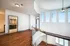 Chic loft-style apartment with elegant curved staircase, expansive windows, and modern hardwood flooring.
