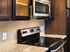 Modern kitchen with sleek stainless steel appliances, elegant granite countertops, and rich dark wood cabinetry.