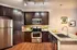 Contemporary kitchen with dark wood cabinets, granite countertops, and stainless steel appliances.