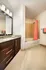 Elegant bathroom with granite countertop, sleek dark wood cabinets, and a stylish red shower curtain.