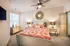Inviting bedroom with vibrant bedding, accentuated by a statement mirror and elegant lighting, creating a cozy and stylish ambiance.
