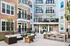 Modern apartment complex with inviting courtyard featuring cozy outdoor seating and a sleek BBQ area, perfect for relaxation and entertaining.