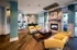 Modern, spacious lounge with stylish yellow chairs, elegant wooden flooring, and a cozy fireplace, perfect for relaxation and productivity.