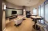 Luxurious entertainment room featuring cozy seating, a sleek modern TV setup, an arcade machine, and stylish poker tables with elegant lighting.