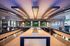 Luxurious modern lounge with sleek design featuring a marble-topped island, ambient overhead lighting, and flat-screen TVs.