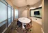 Elegant meeting room with modern design, featuring a sleek oval table, stylish chairs, and a contemporary chandelier under soft lighting.