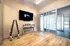 Bright and modern fitness room with sleek equipment, wall-mounted television, and spacious mirrored wall, perfect for a dynamic home workout.