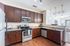 Modern kitchen with sleek stainless steel appliances, rich wooden cabinetry, and stylish pendant lighting, perfect for culinary enthusiasts.