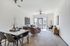 Bright and inviting living space with modern decor, featuring a cozy seating area, dining table, and large windows for natural light.
