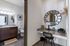 Elegant apartment bathroom and workspace, featuring a modern granite vanity, stylish round mirror, and well-lit decor for a cozy ambiance.