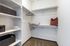 Spacious walk-in closet with carpeted flooring, open shelving, and ample hanging space.