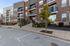 Modern apartment complex exterior with inviting entrance, landscaped greenery, and elegant brick facade.