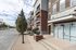 Contemporary urban apartment exterior with brick facade, balconies, and well-maintained landscaping, promising a modern living experience.