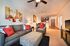 Inviting contemporary living room with comfortable seating, vibrant artwork, and open dining area leading to a modern kitchen.