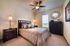 Inviting bedroom with elegant decor, featuring a cozy bed, stylish dark wood furniture, and a large window offering natural light.