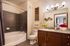 Elegant bathroom with a sleek modern design featuring a luxurious bathtub, stylish vanity with granite countertop, and contemporary lighting for a sophisticated look.
