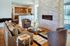 Stylish apartment living room showcasing modern furnishings, a captivating stone fireplace, and an open-concept kitchen with warm lighting.