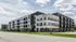 Modern urban apartment complex with sleek architecture, large windows, and stylish balconies.
