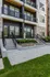 Modern apartment exterior with stylish balconies and inviting entryway, surrounded by lush landscaping.