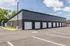 Modern, spacious complex featuring sleek garages and ample parking under a clear blue sky.