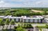 Modern apartment complex surrounded by lush greenery and open fields, offering a serene living environment.