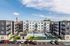 Contemporary apartment complex featuring sleek modern architecture, vibrant pool area, and inviting outdoor lounge spaces against a bright blue sky.