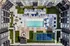 Chic aerial view of a luxurious apartment complex featuring a stylish swimming pool, sun loungers, shaded seating areas, and a modern tennis court.