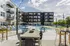 Chic urban apartment complex featuring a pristine pool, stylish outdoor lounge, and modern seating amidst a vibrant community setting.