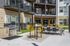 Modern apartment complex courtyard with outdoor seating and a stylish stainless steel grill area, perfect for entertaining.