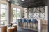 Chic, modern lounge area with high ceilings, stylish bar stools, and contemporary decor, perfect for casual meetings.