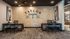 Chic office space with elegant wood paneling, modern artwork, and inviting seating area.
