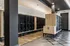 Modern apartment mailroom featuring sleek black mailboxes, wood accents, and stylish lighting for a sophisticated ambiance.