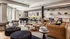 Modern and inviting living room with plush gray sofas, stylish leather couches, and a contemporary pool table, filled with natural light and chic decor.
