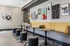Contemporary lounge space with vibrant artwork, stylish yellow seating, and modern round tables, perfect for relaxation and socializing.