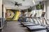Modern fitness center with sleek treadmills, vibrant geometric mural, and large windows for natural light.