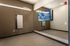 Modern gym room featuring a sleek Echelon Reflect mirror and a large wall-mounted TV, perfect for immersive workouts.