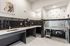 Modern pet washing station with elegant black tiling, featuring a large stainless steel tub and charming paw print decor.
